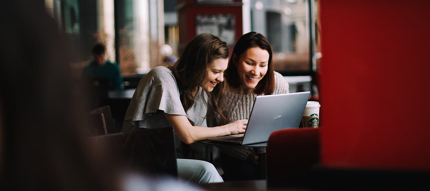 Image of two women sitting together with a laptop.
