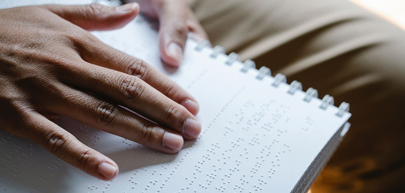Close up image of a person reading Braille.