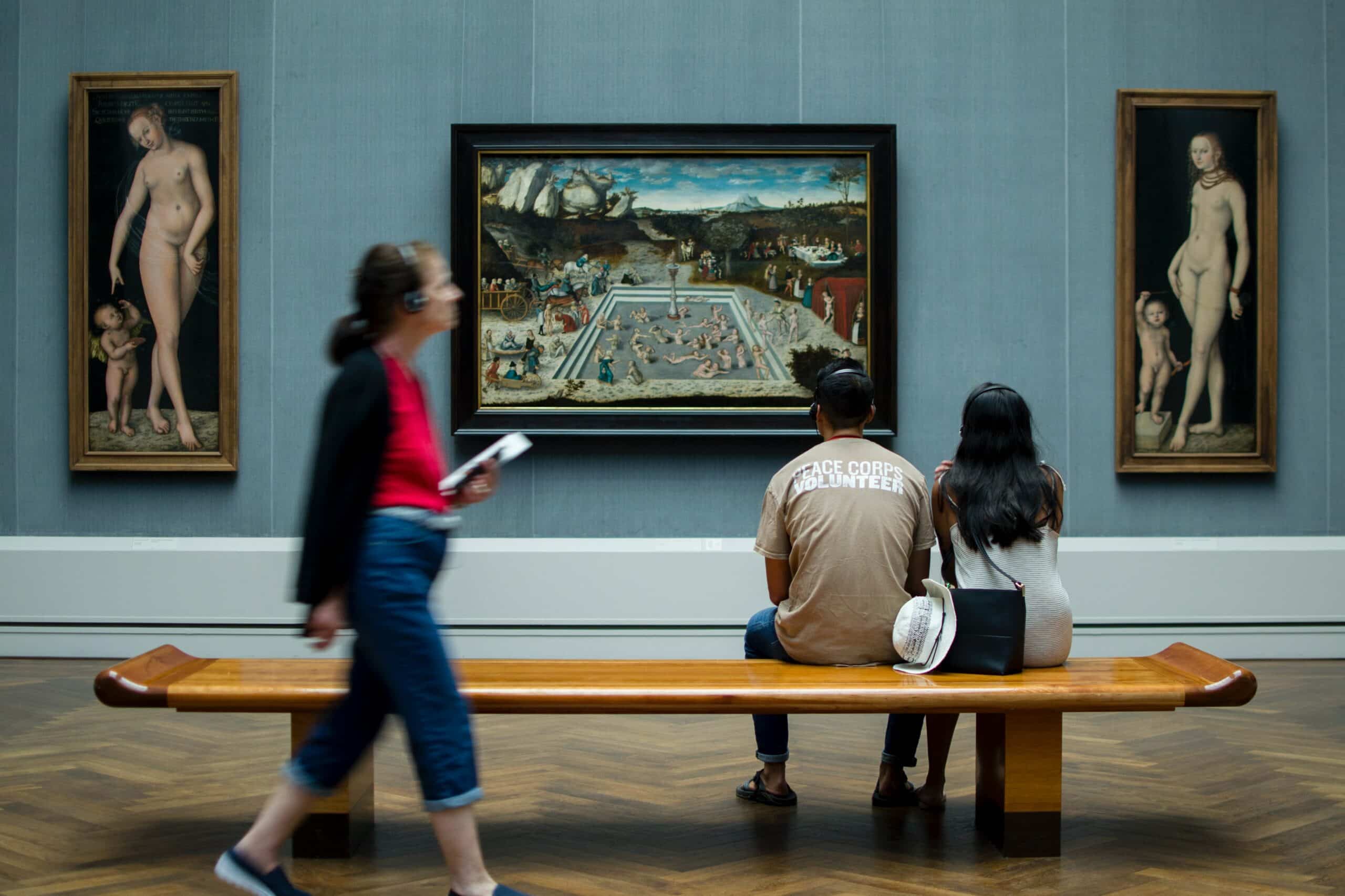 Photograph of museum visitors looking at a painting