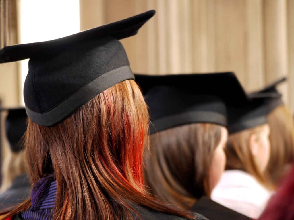 back of a person with brownish red hair wearing a graduation hat
