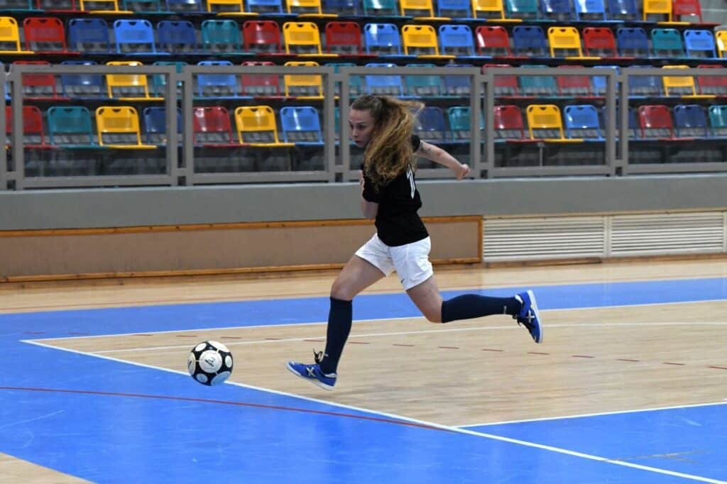 Futsal player kicking ball