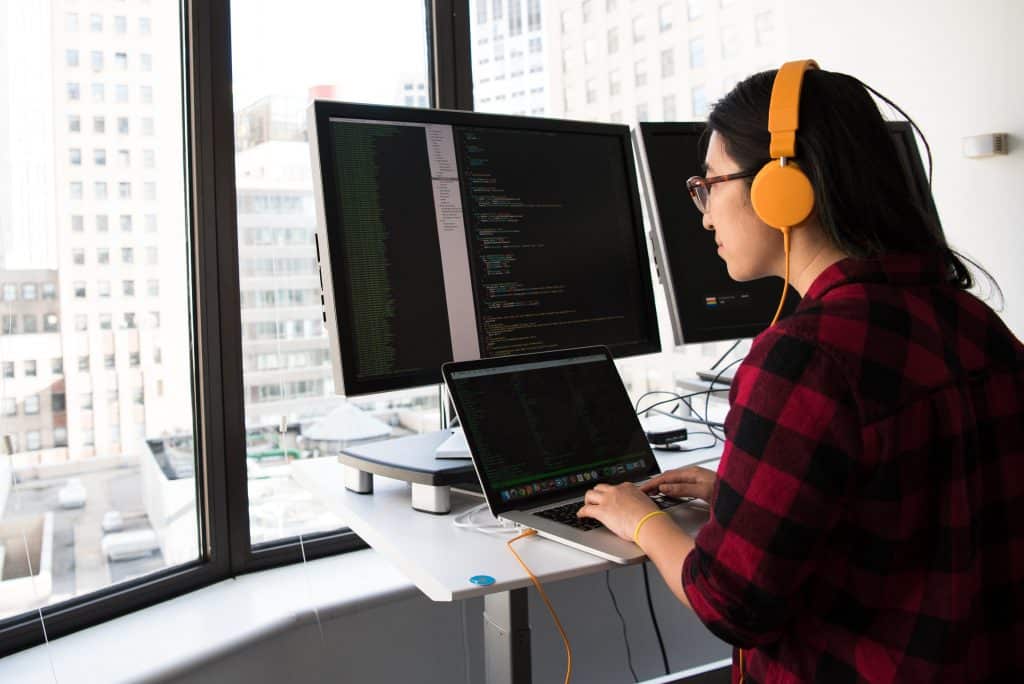 Woman working on computer wearing headphones