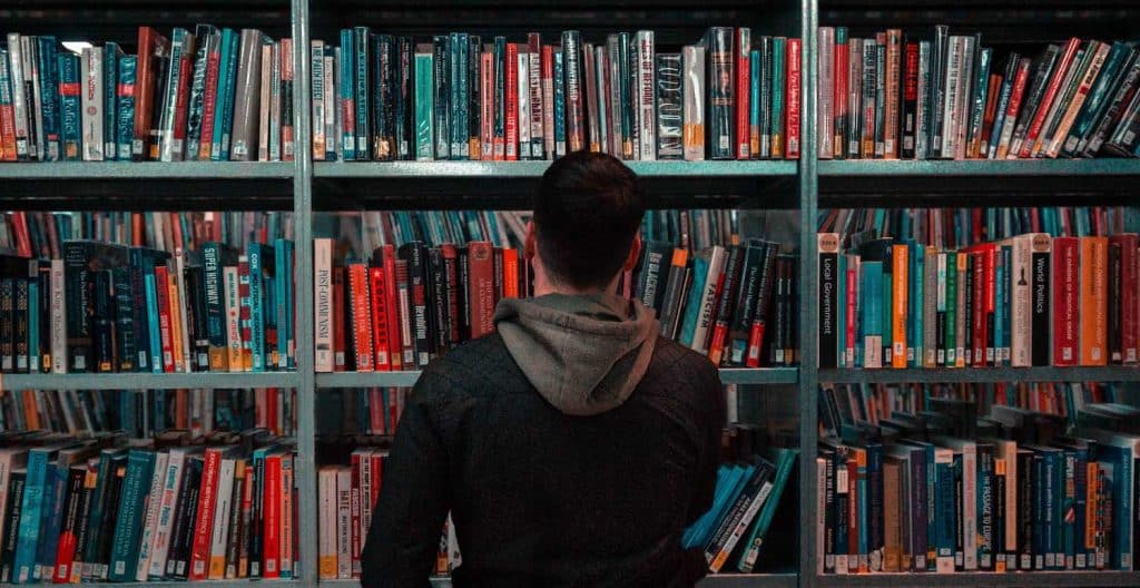 Image of a person standing in front of a bookshelf