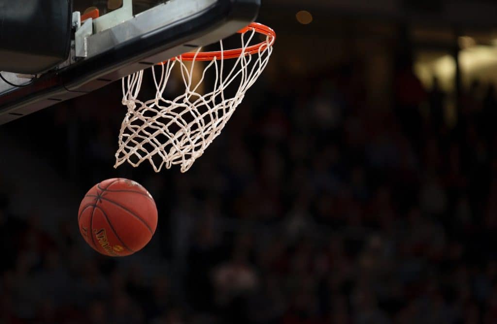 Close up image of a basketball net and basketball flying in the air.