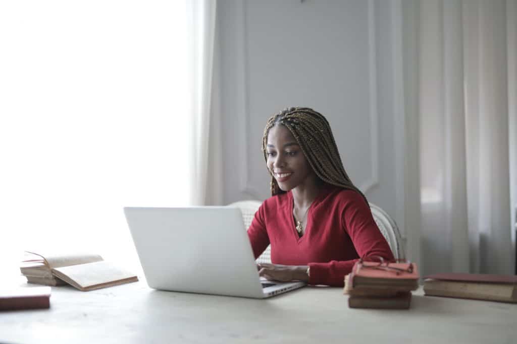 Image of a woman looking at her laptop at a desk space.