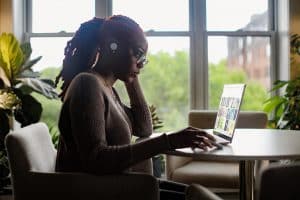 Image of a woman using a laptop at a desk space.