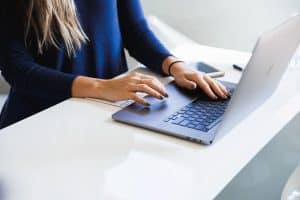 Close up image of a woman using a laptop.